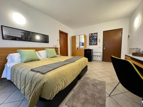 1 dormitorio con 1 cama grande, escritorio y sillas en Residence Malpensa en Somma Lombardo