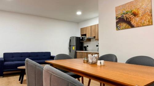 a dining room with a table and a blue couch at Edificio Tofino in Quito
