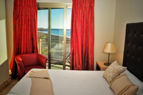 a bedroom with a bed and a chair and a window at LAS MAREAS in Tazacorte