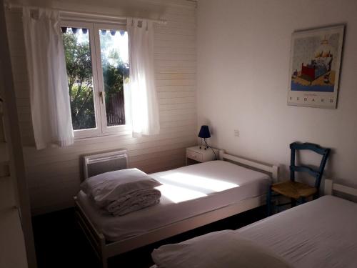 a bedroom with two beds and a window at villa les Arbousiers in Vieux-Boucau-les-Bains