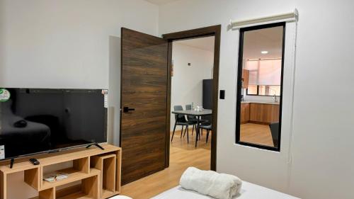 a living room with a television and a mirror at Edificio Tofino in Quito
