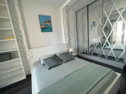 une chambre avec un lit et une grande fenêtre dans l'établissement Magnifique appartement avec vue sur mer, à Nice