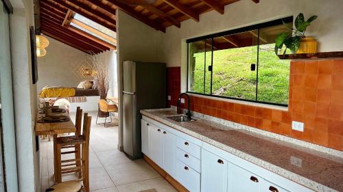 una cucina con un lavandino e una finestra di Cabana Rinoceronte a São Bento do Sapucaí