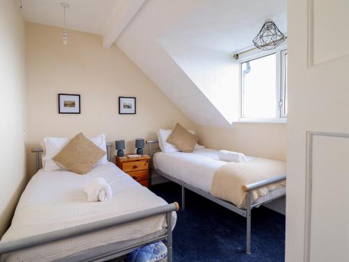 2 camas en una habitación con ventana en Tawelfan, en Llwyngwril