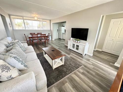 a living room with a couch and a tv and a table at Wondrous Waterfront Condo w/ Pool & Washer/Dryer in Fort Walton Beach