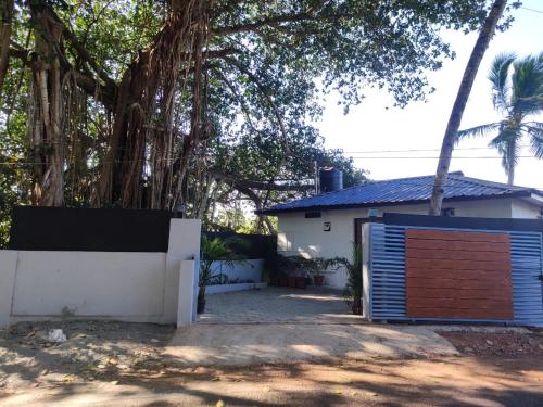 a house with a wooden garage door in front of it at The Bay Talpona Guest House in Goa