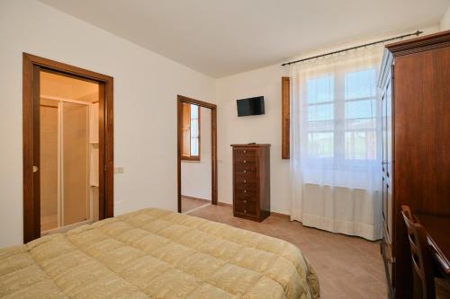 a bedroom with a bed and a dresser and a window at 8380 Agriturismo il Saragiolo in Manciano