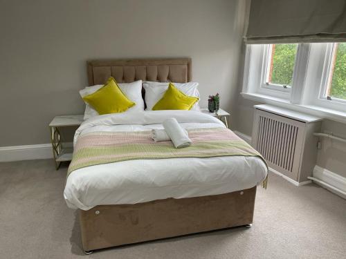 een slaapkamer met een groot bed met gele kussens bij Upper Berkely Suits Falcon Group in Londen