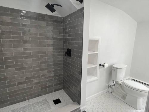 ein Bad mit einem WC und einer gefliesten Dusche in der Unterkunft Quiet and Cozy Getaway in Milford in Milford