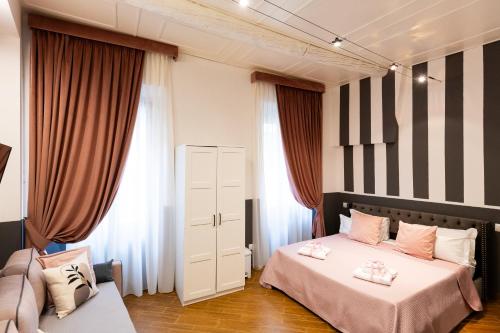 a bedroom with two beds and two windows at Santa Croce Dream Suites in Florence