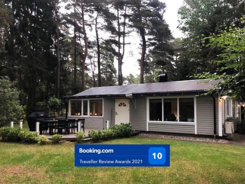 a tiny house with a table in a yard at Nordic Relax House - WoodHouse in Sjöbo