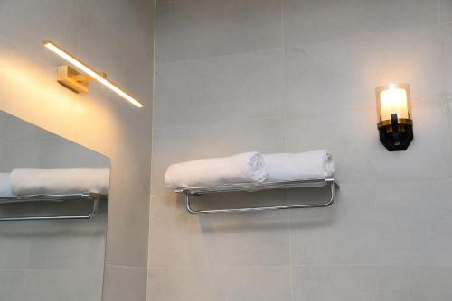 La salle de bains est pourvue d'un porte-serviettes et d'une lumière sur le mur. dans l'établissement Hanthana Heritage, à Kandy