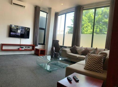a living room with a couch and a tv at Modern One Bedroom Apartment in North ridge in Accra