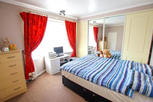 a bedroom with a bed and a dresser and a mirror at 3 bedrooms Sleeps 8 Self Catering House Near California Cliffs and Great Yarmouth Beach,Norfolk in Earlham