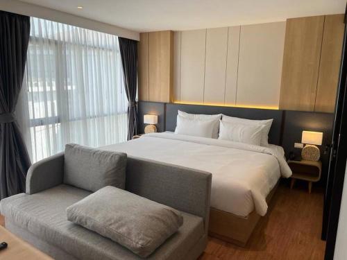 ein Hotelzimmer mit einem großen Bett und einem Sofa in der Unterkunft Sea Beach apartment in Nai Thon Beach