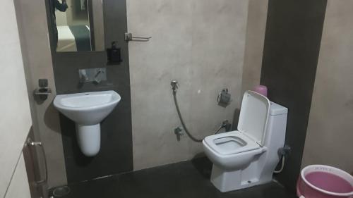 a bathroom with a toilet and a sink at HOTEL INDRANI in Chittaurgarh