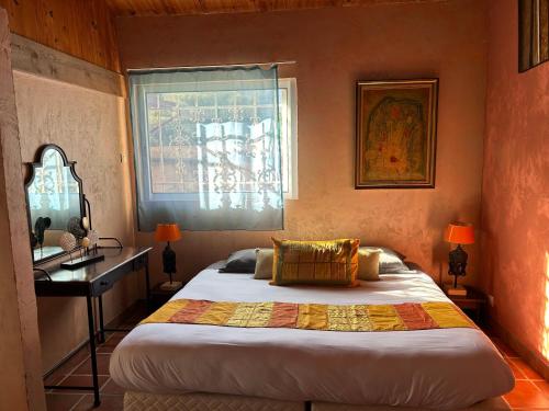 a bedroom with a bed and a desk and a window at Casa di Floumy in Calvi