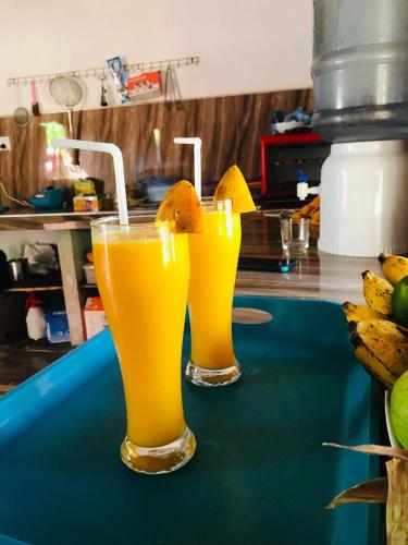 two glasses of orange juice sitting on a counter at Dolphin Village in Kalpitiya
