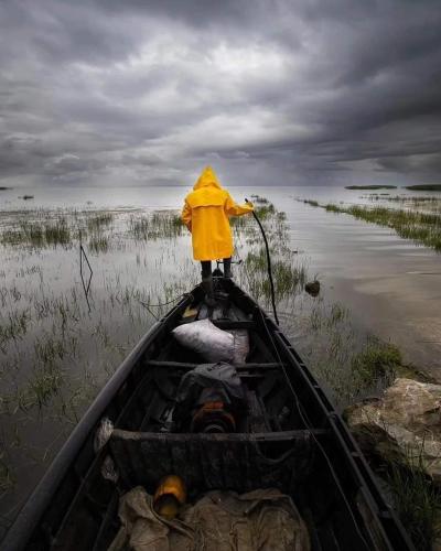a person in a boat in the water at Cabañas Villas Del Lago in Cuítiva