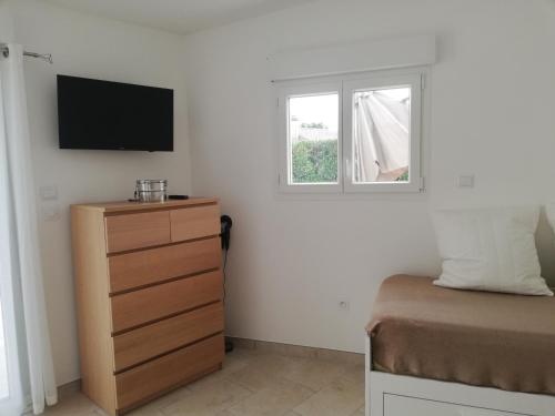 a bedroom with a bed and a dresser and a window at Studio NEUF avec piscine in Tulette