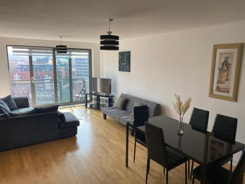 a living room with a couch and a table at EEJs Beautiful 2 bed Apartment - Sheffield centre in Sheffield