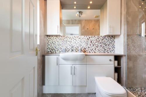 a white bathroom with a sink and a toilet at Stratford House - Perfect for a get together in Upton Snodsbury