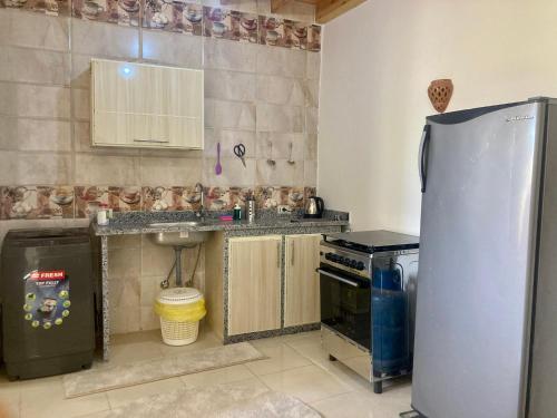 uma pequena cozinha com um frigorífico e um lavatório em Charming Garden near Beach+bike em Dahab