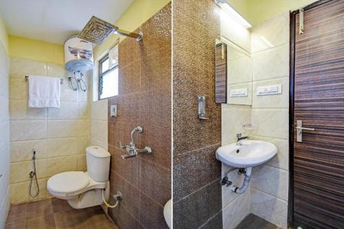a bathroom with a shower and a toilet and a sink at Hotel Elite Inn Ultadanga Inn Kolkata in Kolkata