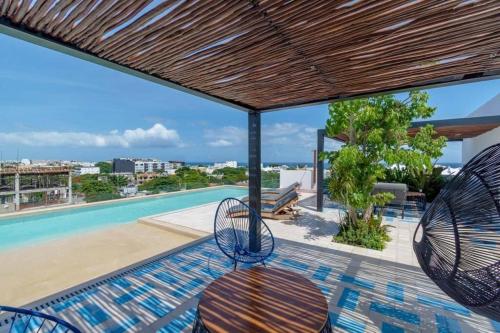 a patio with chairs and a swimming pool at Nuevo y lujoso estudio céntrico in Playa del Carmen