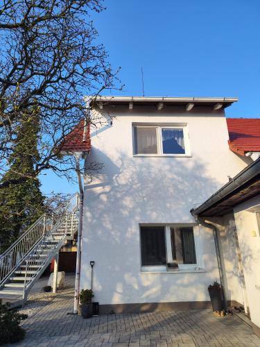 a white house with a staircase next to it at Apartmán Ptice in Ptice