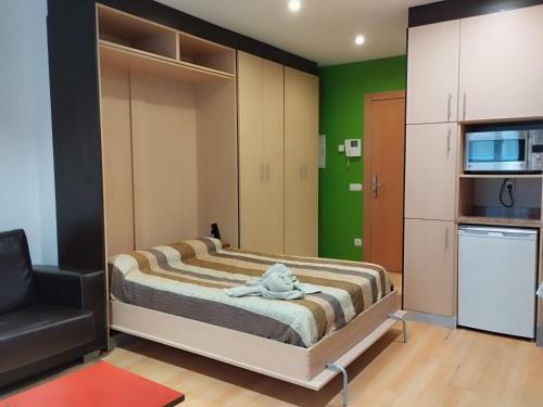 a small bedroom with a bed and a chair at Estudio Céntrico B4 in Oviedo