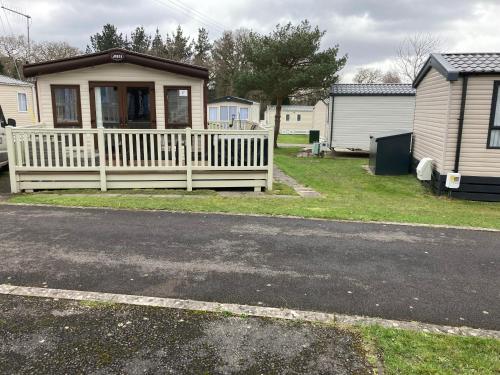a house with a white fence in a yard at Bluebell in Ferndown