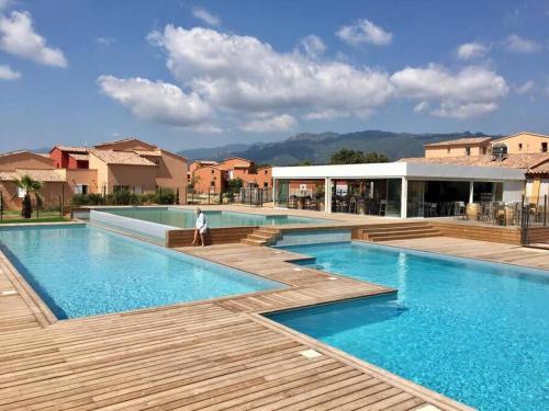 une personne debout en face d'une piscine dans l'établissement T3 Madiana, Climatisé, piscines, resto, 5mn plages, à Lecci