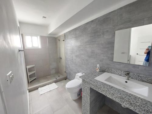 a bathroom with a white toilet and a sink at Villa bayahibe 103 in San Rafael del Yuma