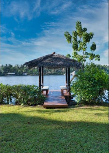 a gazebo with a table and chairs next to the water at The Lake House Koggala in Galle