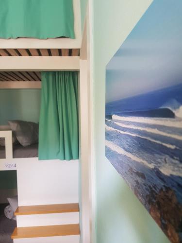 a bedroom with bunk beds with a picture of the ocean at Conde Surf Camp - junto ao mar - entire pvt house in Vila do Conde