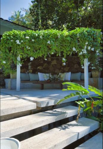 a pergola with plants on it sitting on some stairs at The Lake House Koggala in Galle