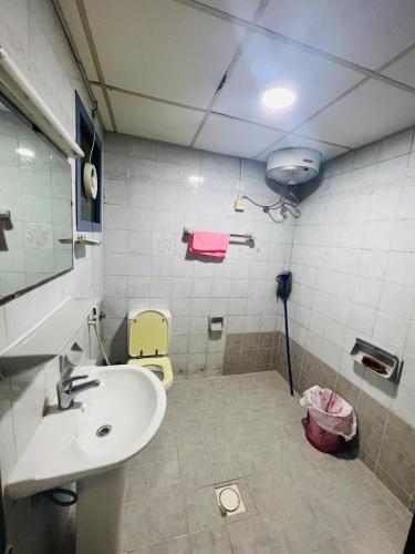 a bathroom with a sink and a toilet and a mirror at Sweet Home in Dubai