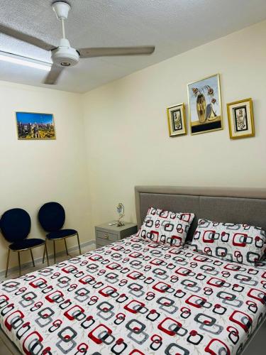 a bedroom with a large bed with two blue chairs at Sweet Home in Dubai