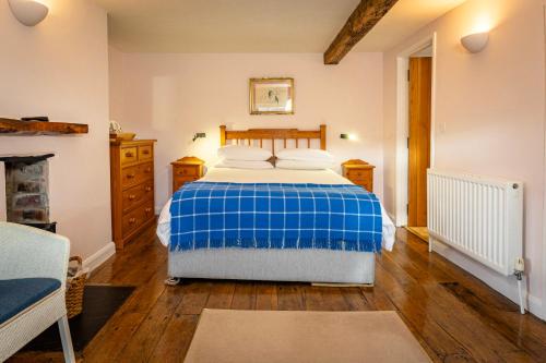a bedroom with a blue and white bed and wooden floors at Ty Newydd B&B in Brecon