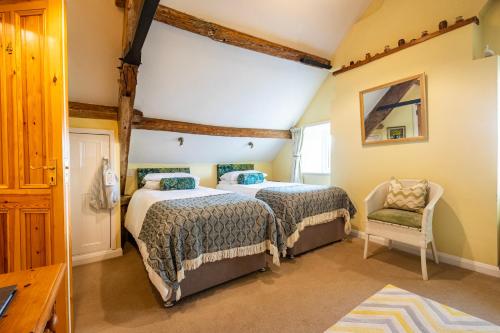 a bedroom with two beds and a chair at Ty Newydd B&B in Brecon