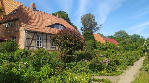 an old house with a garden in front of it at Ferienwohnung Apfelgarten am Pfarrgarten Starkow in Velgast