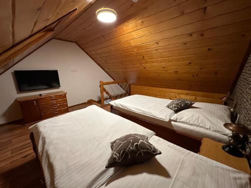 um quarto com duas camas e uma televisão num camarote em Penzión Gitka em Vrútky