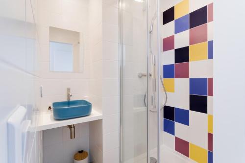 uma casa de banho com um chuveiro e um lavatório azul em La Serrisienne 7 - Val d'Europe - Disneyland Paris - 6 à 8 Personnes em Serris