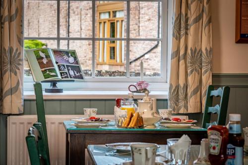 a table with plates of food and a window at Ty Newydd B&B in Brecon
