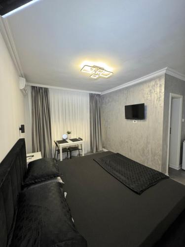 a living room with a bed and a television at Casa Ștefan in Eforie Sud