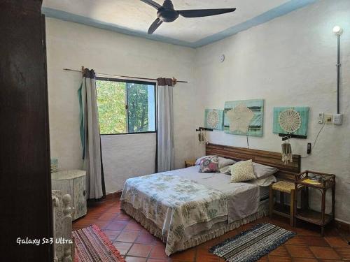 Schlafzimmer mit einem Bett und einem Deckenventilator in der Unterkunft Espacios amplios con terraza y piscina spa in San Lorenzo