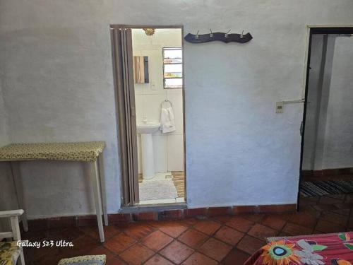 über eine Tür zu einem Bad mit einem Waschbecken und einem Spiegel in der Unterkunft Espacios amplios con terraza y piscina spa in San Lorenzo