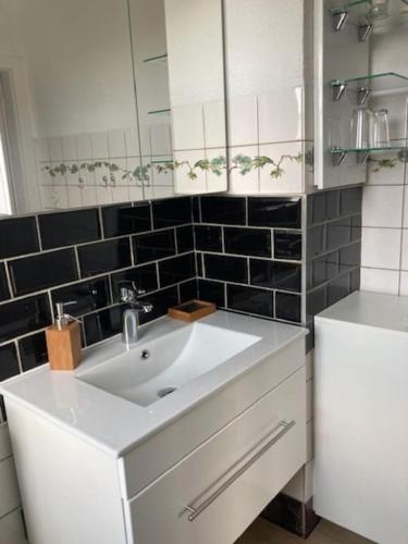 W łazience znajduje się biała umywalka i lustro. w obiekcie Wohnen im Grünen bei der Töpferei w mieście Erfurt