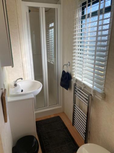 a bathroom with a sink and a toilet and a window at Static van on Smallgrove in Ingoldmells in Skegness